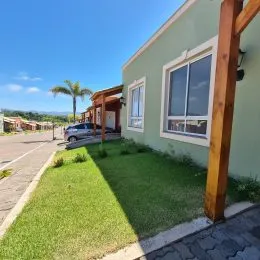 Vista externa mostrando um gramado verde em frente à residência.
