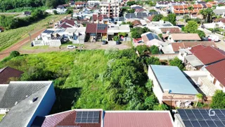 Vista aérea de um bairro residencial com telhados e vegetação.