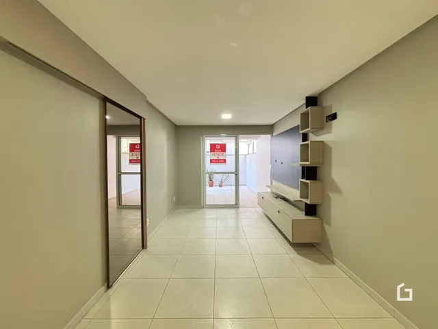 Corredor interno de uma residência com piso de cerâmica e paredes claras.