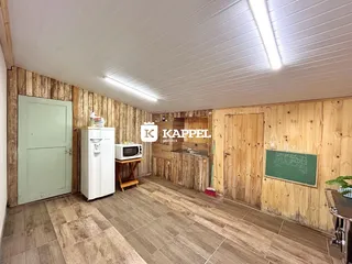 Cozinha com revestimento de madeira nas paredes e piso de porcelanato.