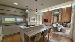 Interior de uma sala de estar com cozinha aberta em um apartamento no Brasil.