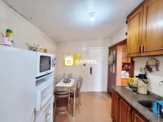 Foto interna de uma área de cozinha e sala de jantar com armários de madeira.