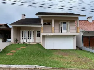 Fachada de uma casa residencial em Lajeado, Brasil, com garagem e jardim gramado.