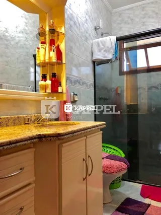 Foto de uma bancada de cozinha com prateleiras amarelas e armários claros.