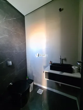 Foto de um banheiro com revestimento de mármore escuro.