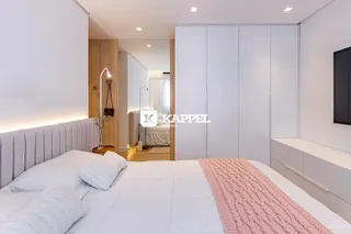 Quarto com cama grande e armários embutidos brancos.