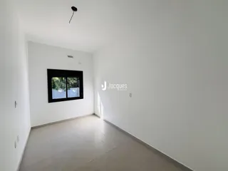 Interior de um ambiente com paredes brancas e piso claro.