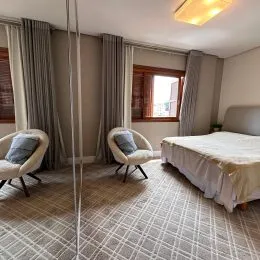 Quarto com cama e piso de carpete em um imóvel.