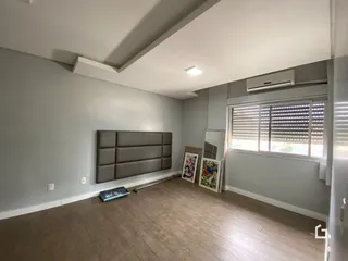 Uma sala de estar com paredes cinzas e piso de madeira clara.