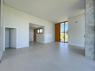 Espaço interno amplo com paredes brancas e piso claro.