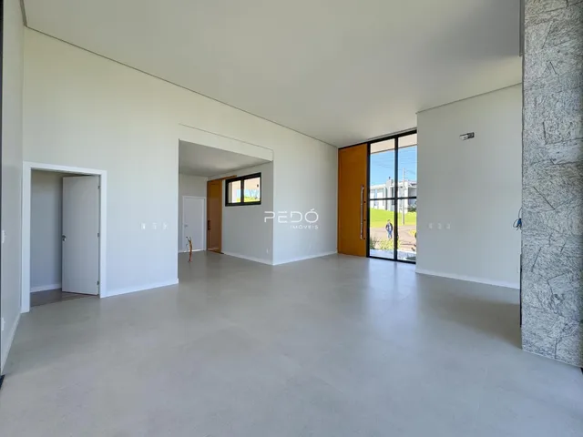 Espaço interno amplo com paredes brancas e piso claro.