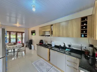 Cozinha com armários de madeira e piso claro.