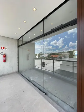 Vista de uma área externa com portas de vidro que dão para um pátio.