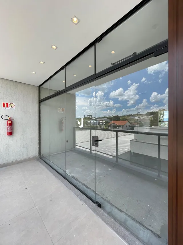 Vista de uma área externa com portas de vidro que dão para um pátio.