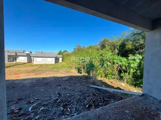 Vista externa da propriedade com vegetação densa ao fundo.