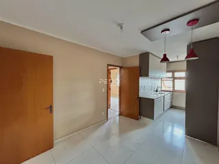 Interior de uma sala de estar com cozinha em um imóvel.