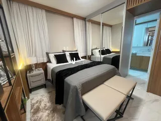 Um quarto com cama e cortinas brancas em um imóvel.