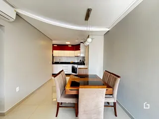 Uma sala de jantar com mesa e cadeiras em um apartamento moderno.