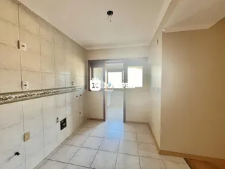 Corredor interno com revestimento de azulejos claros e piso de cerâmica.