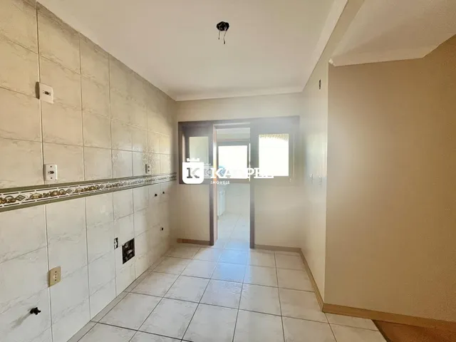 Corredor interno com revestimento de azulejos claros e piso de cerâmica.