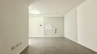 Vista interna de um corredor com paredes brancas e piso de cerâmica.