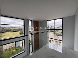 Sala de estar com grandes janelas que oferecem uma vista panorâmica da paisagem.