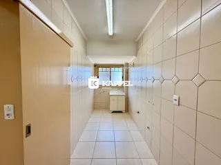 Um corredor interno com piso e paredes revestidos de azulejos claros.