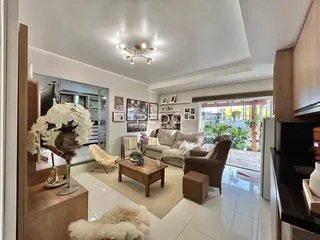 Sala de estar com piso de cerâmica e móveis de madeira clara.
