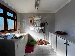 Esta é uma foto de uma cozinha com janela e armários brancos.
