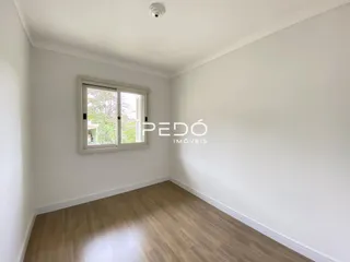 Quarto interno com piso de madeira e janela.