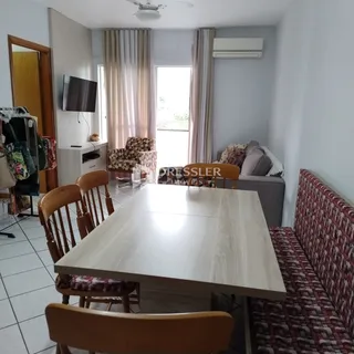 Sala de estar com sofá e mesa de jantar em um apartamento no Brasil.