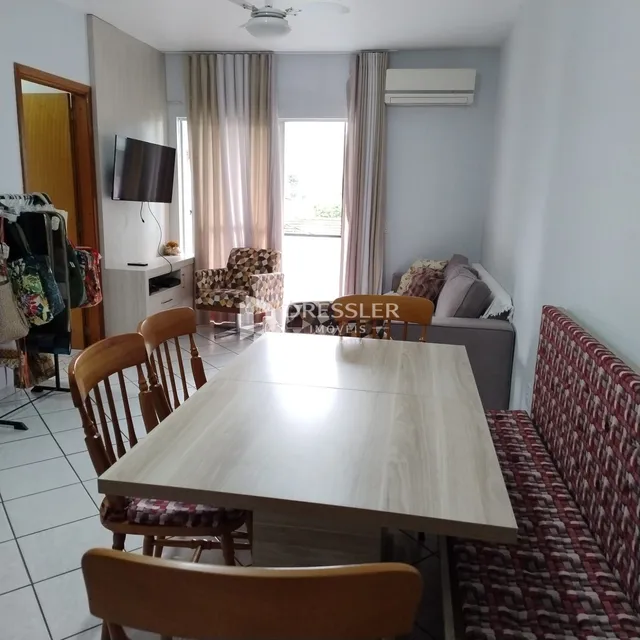 Sala de estar com sofá e mesa de jantar em um apartamento no Brasil.