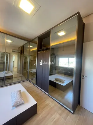 Interior de um ambiente com divisórias de vidro e piso de madeira.