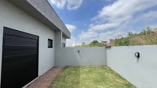 Fachada externa de uma residência com muro e gramado.