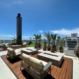 Área externa com deck de madeira, móveis e plantas em um imóvel em Lajeado.