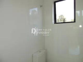 Foto de um ambiente interno com um vaso sanitário e uma janela.
