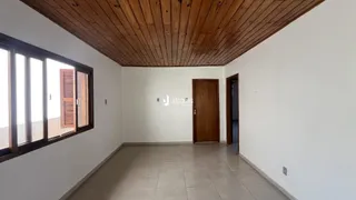 Ambiente interno com piso de cerâmica e teto de madeira em uma residência.