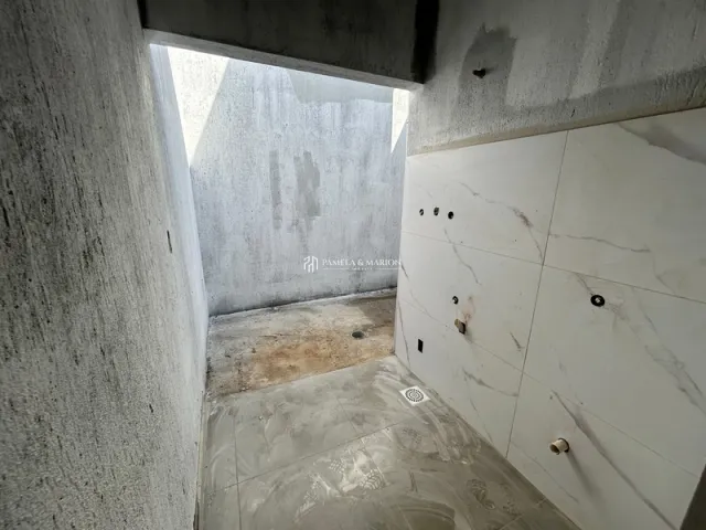 Vista de um corredor com paredes de concreto aparente em um imóvel.