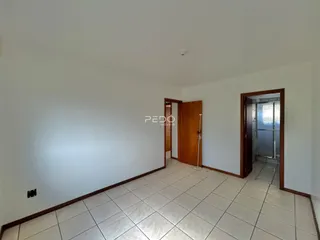 Espaço interno com piso de cerâmica e molduras de madeira.