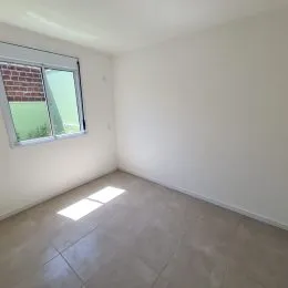 Vista de uma sala com grande janela iluminada.