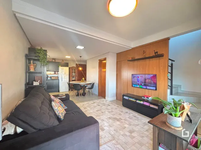 Sala de estar com decoração moderna e cozinha integrada em imóvel no Lajeado.
