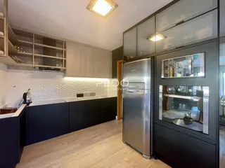 Vista da cozinha moderna com armários e piso de madeira clara.