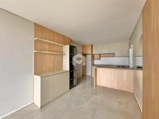 Interior de uma sala de estar com armários de madeira clara e piso de cerâmica.