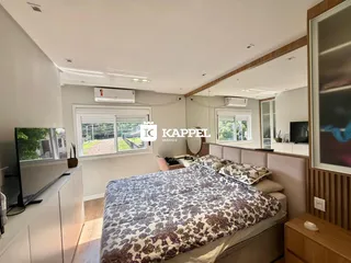 Quarto com cama grande e janelas em um imóvel no Brasil.