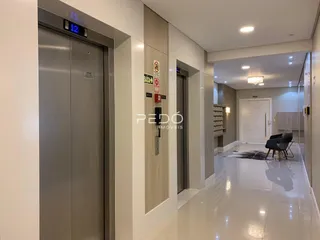 Hall de entrada de um apartamento moderno com piso claro e detalhes em madeira.