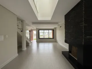 Corredor moderno com piso de cerâmica e parede de tijolos na área residencial.