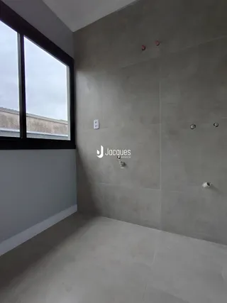 Ambiente interno com paredes cinzas e uma grande janela.