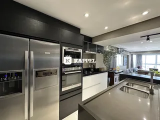 Foto de uma cozinha moderna com armários escuros e bancadas claras.