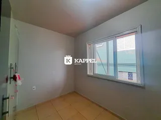 Foto de um cômodo interno com paredes claras e piso de cerâmica.