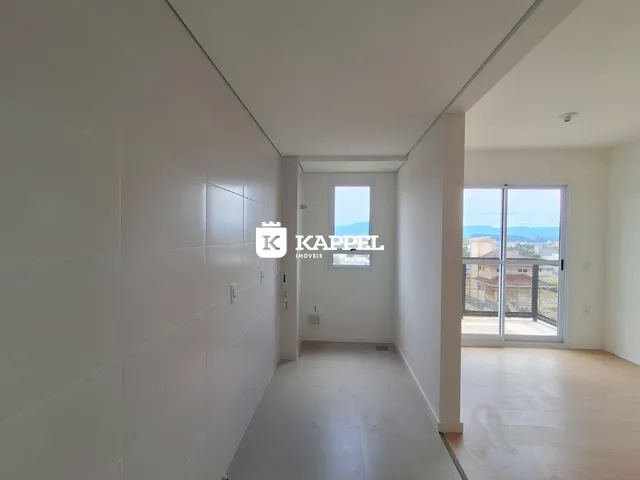 Um corredor interno de uma residência moderna com paredes brancas e piso claro.